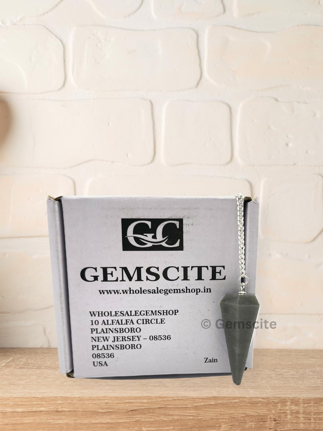 Wholesale Gem Shop blue aventurine pendulum resting on velvet pouch for gifting