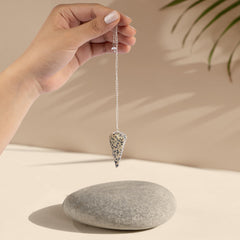 Wish Well pendulum in-hand close-up highlighting Dalmatian Jasper for intuition guidance.