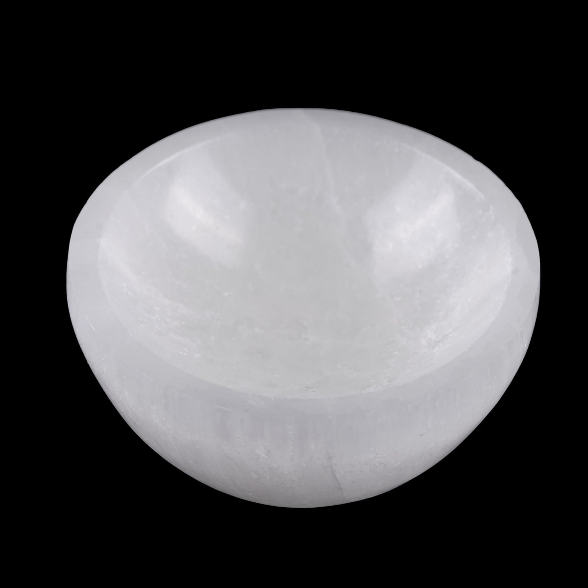 Wish Well selenite bowl on a bedside table cleanses crystals' energy overnight
