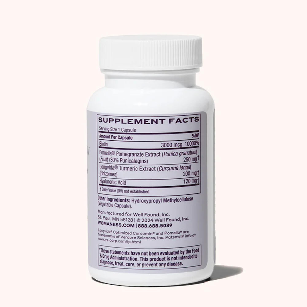 Womaness Active Glow capsules closeup featuring biotin and hyaluronic acid for hair and skin support