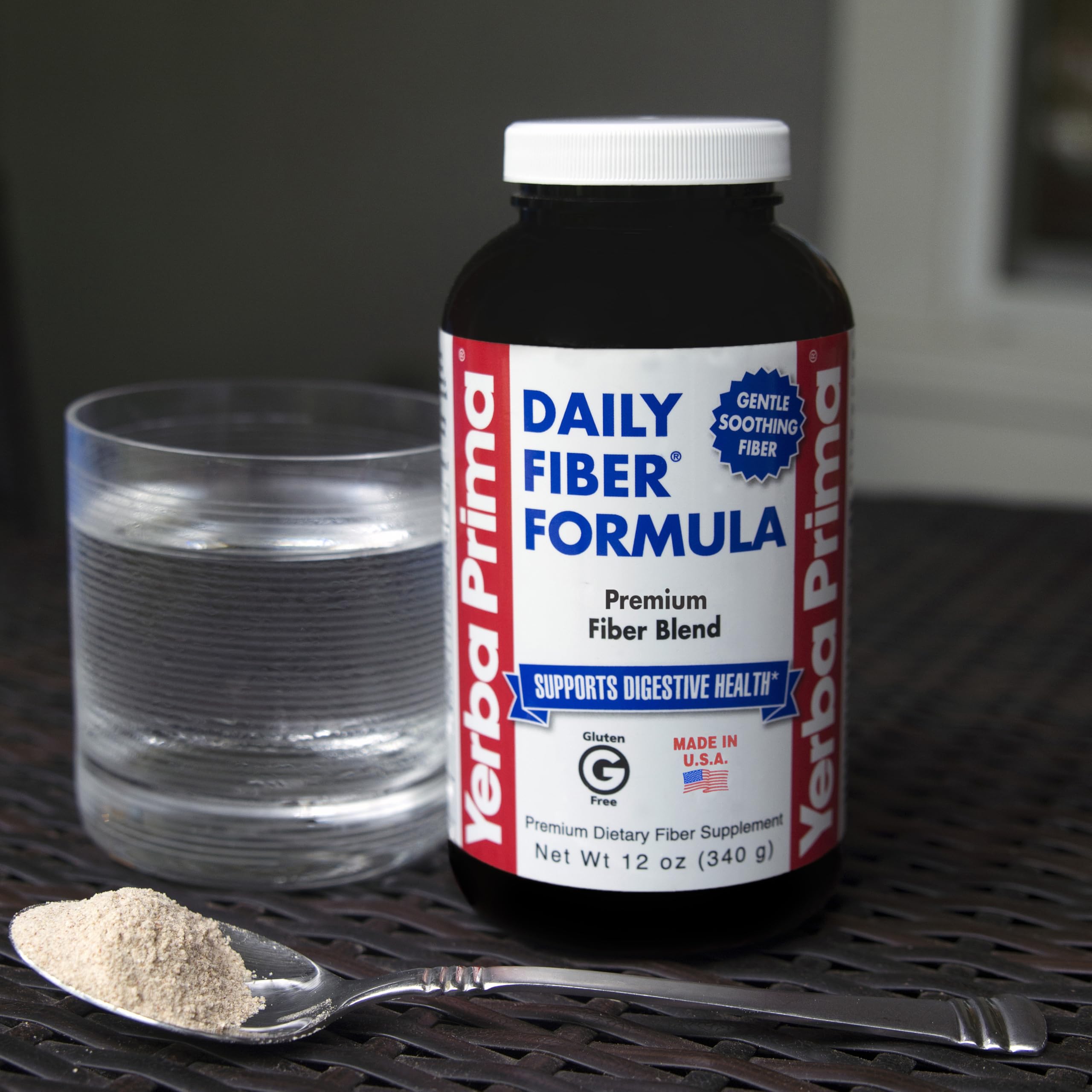 Scoop of Yerba Prima powder next to a glass showing convenient daily intake.