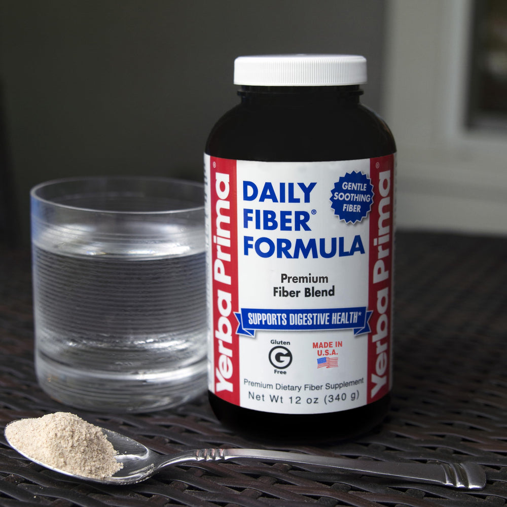 Scoop of Yerba Prima powder next to a glass showing convenient daily intake.