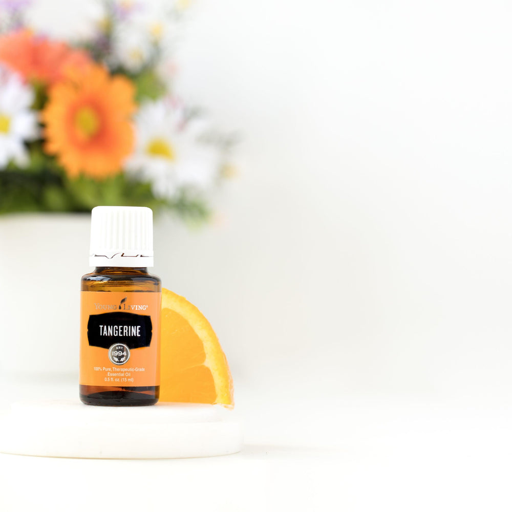 Fresh Tangerine citrus slices paired with Young Living bottle for zest