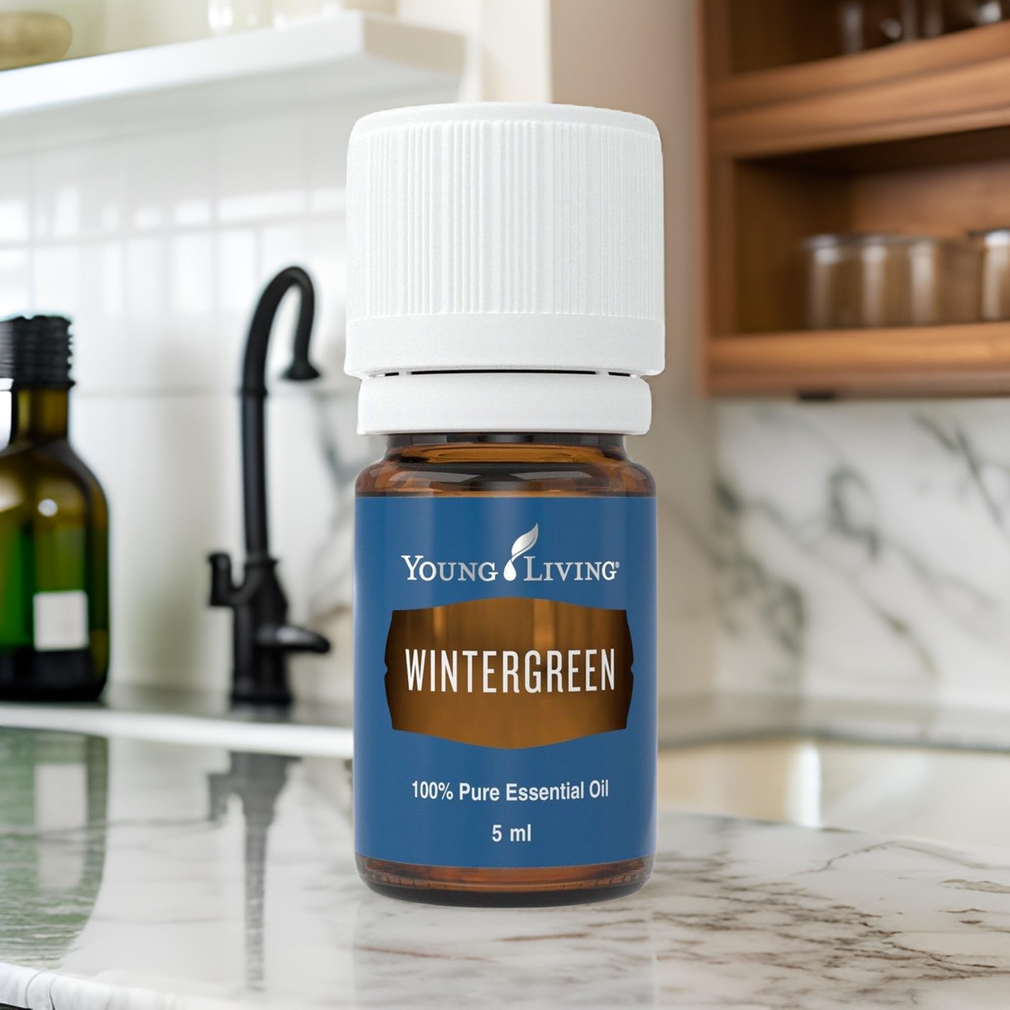Young Living Wintergreen oil drops into hand for a quick aroma check.