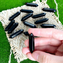 ZHIYUXI obsidian pointed stone held in hand for calm focus.