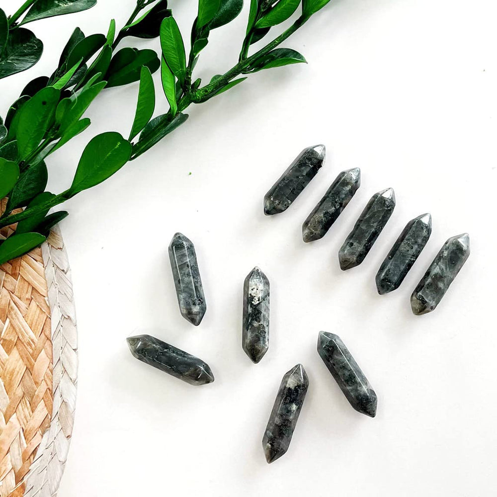 Baguettes en labradorite noire ZHIYUXI tenues en main pour calmer l'esprit.